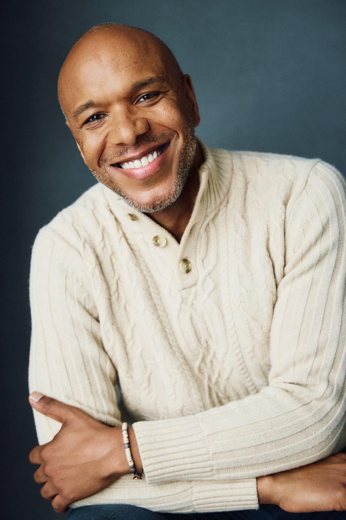 Alfred C. Kemp in a cream sweater against a dark backdrop