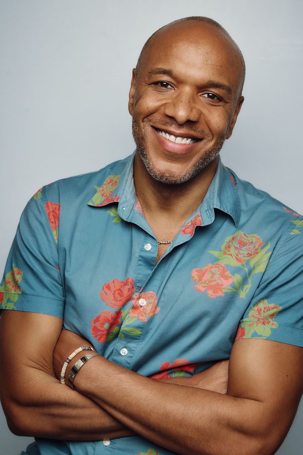 Alfred C. Kemp headshot, teal floral shirt, arms crossed, smiling
